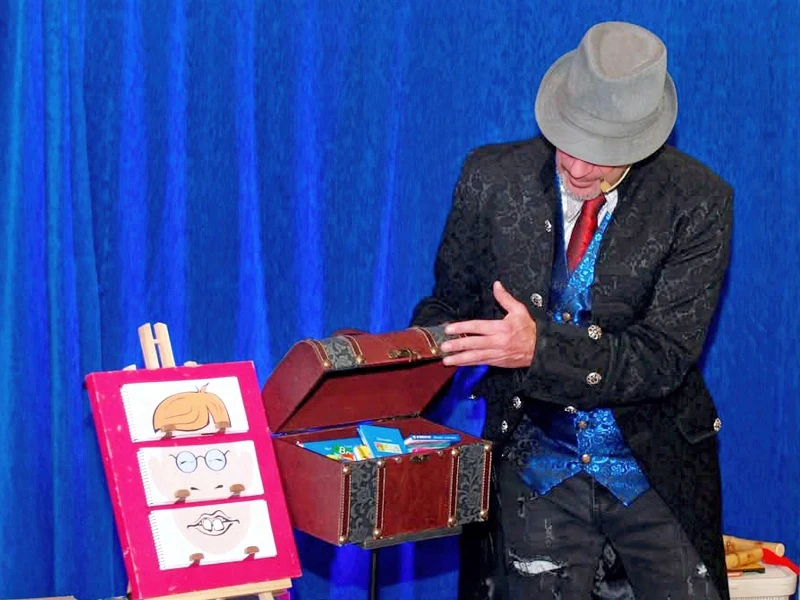 Pedro III abre un cofre del tesoro junto a un cartel de expresiones en el escenario